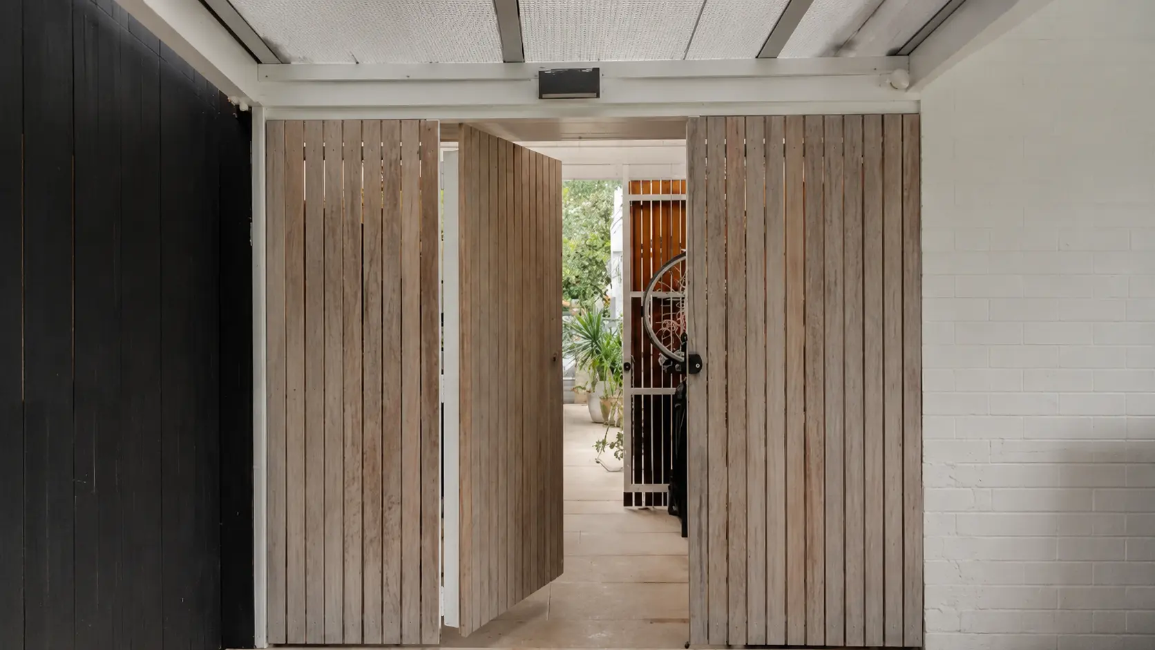 Internal Carpentry Sydney modern living room with built-in timber shelving, wall panelling, and floating media cabinet in a bright contemporary home interior.