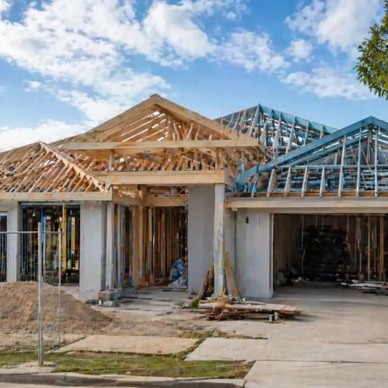 Structural roofing in Sydney showing exposed timber trusses and steel framing during residential roof construction stage